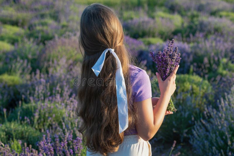 En femtonårig flicka i lavender provence. vacker ung flicka i en lavandeprovokation vid solnedgången. provokationsflicka på