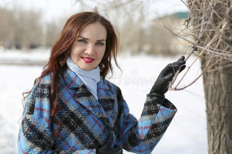 En flicka går i våren på snö och vatten arkivfoton