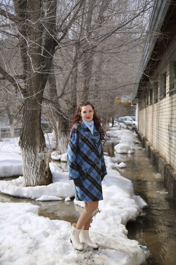 En flicka går i våren på snö och vatten royaltyfri fotografi