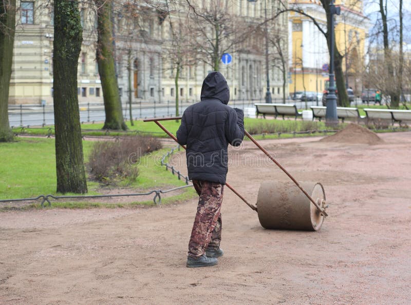 A street worker rams the ground with a hand roller, Admiralteyskaya Embankment, St. Petersburg, Russia, April 22, 2024. A street worker rams the ground with a hand roller, Admiralteyskaya Embankment, St. Petersburg, Russia, April 22, 2024