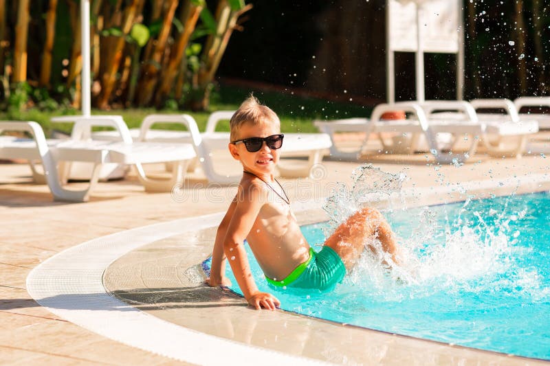 En glad liten pojke som hade kul på poolen på resorten arkivfoton