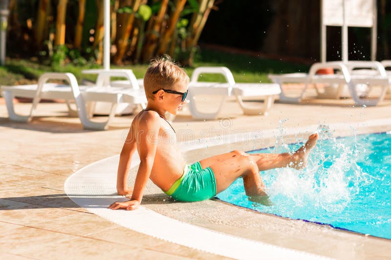 En glad liten pojke som hade kul på poolen på resorten fotografering för bildbyråer