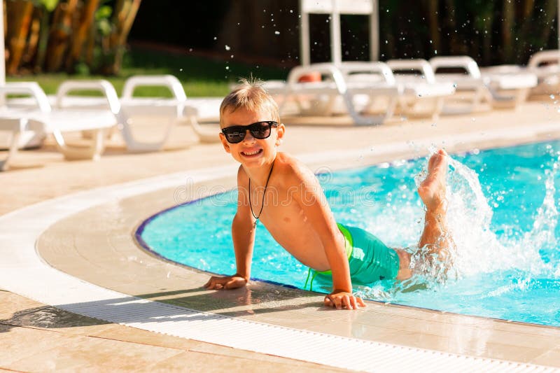 En glad liten pojke som hade kul på poolen på resorten arkivfoto