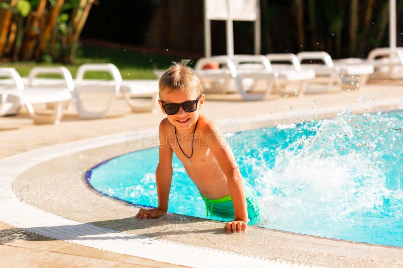 En glad liten pojke som hade kul på poolen på resorten royaltyfri fotografi