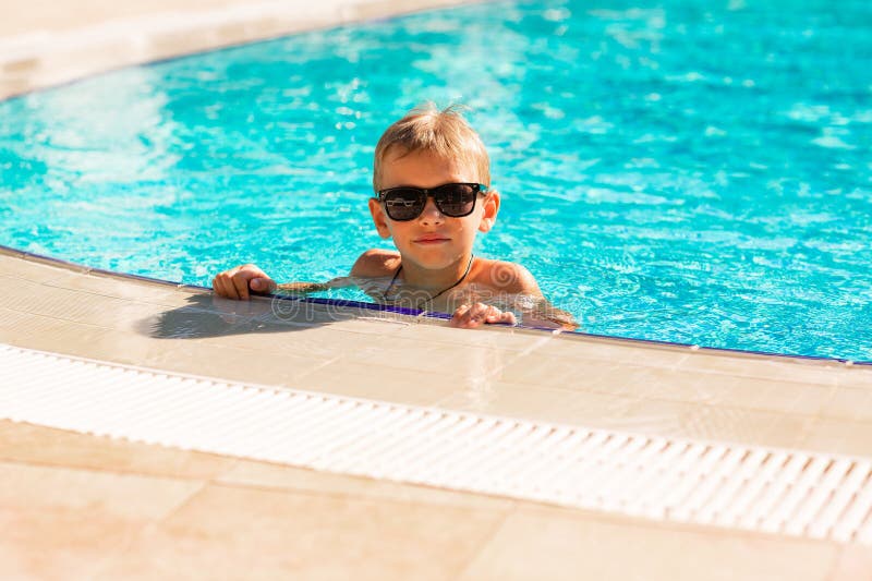 En glad liten pojke som hade kul på poolen på resorten royaltyfri bild