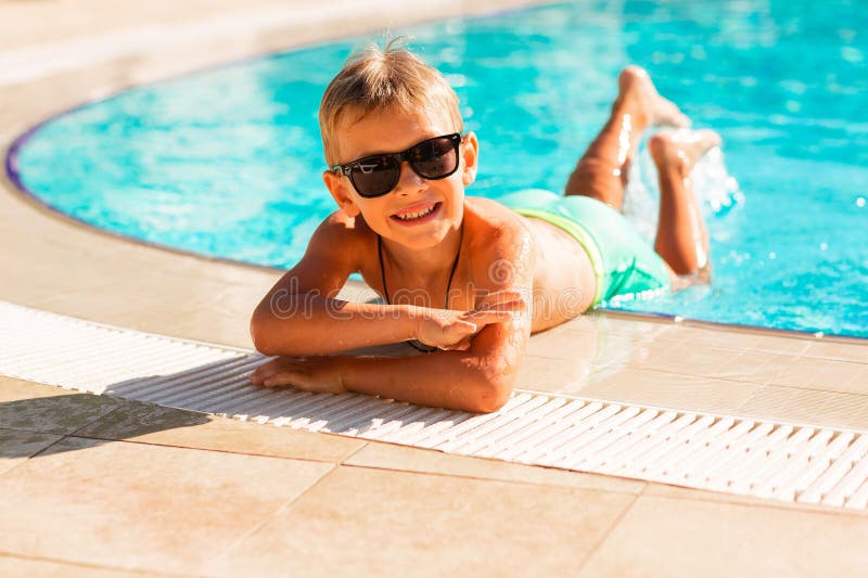 En glad liten pojke som hade kul på poolen på resorten royaltyfri fotografi