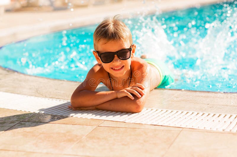 En glad liten pojke som hade kul på poolen på resorten arkivbild