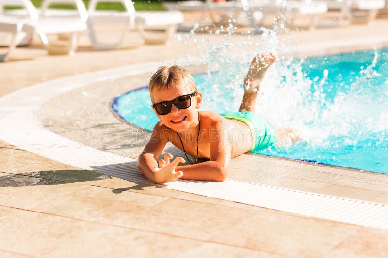En glad liten pojke som hade kul på poolen på resorten royaltyfri foto