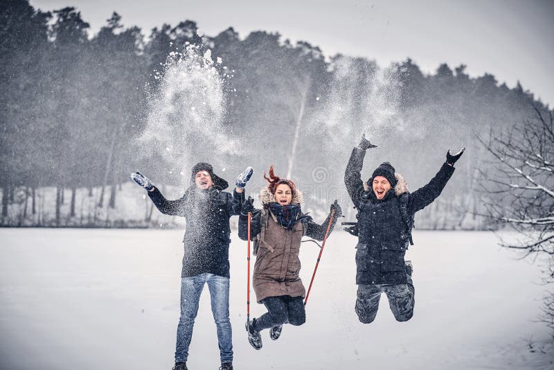 En grupp av glade vänner som har gyckel tillsammans i en snöig skog arkivfoton En grupp av glade vänner som har gyckel tillsammans i en snöig skog arkivfoton