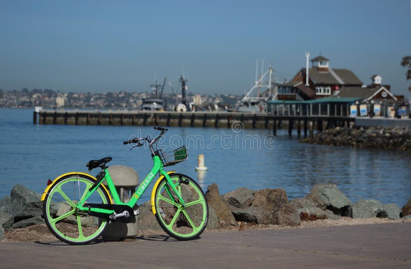 En gräsplan Limebike parkeras framme av by för hamnstad för San Diego ` s royaltyfria bilder En gräsplan Limebike parkeras framme av by för hamnstad för San Diego ` s royaltyfria bilder