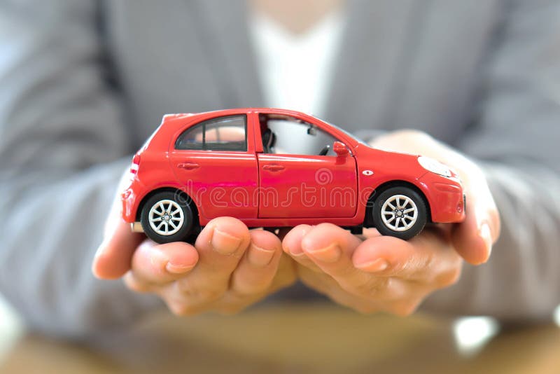 En hand med bilen Begreppsbakgrund för auto återförsäljare och hyra arkivfoto En hand med bilen Begreppsbakgrund för auto återförsäljare och hyra arkivfoto