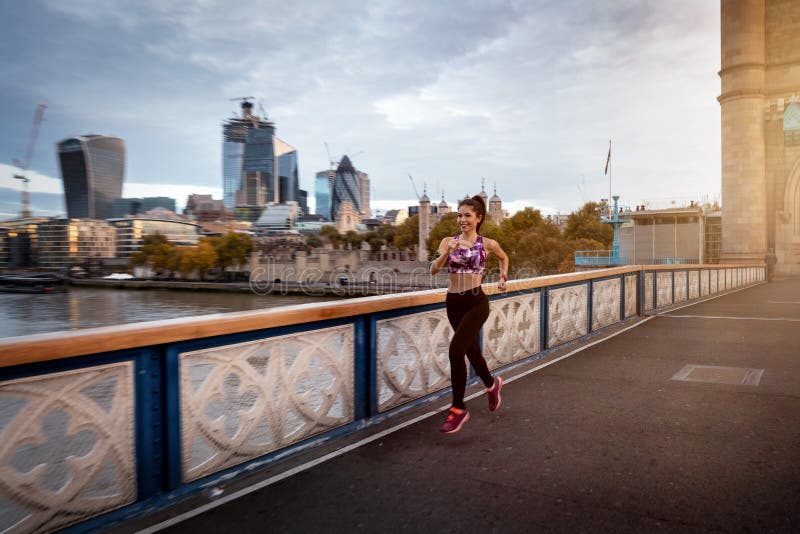 En idrottslig kvinna gillar hennes träningssession framför Llondons citycape