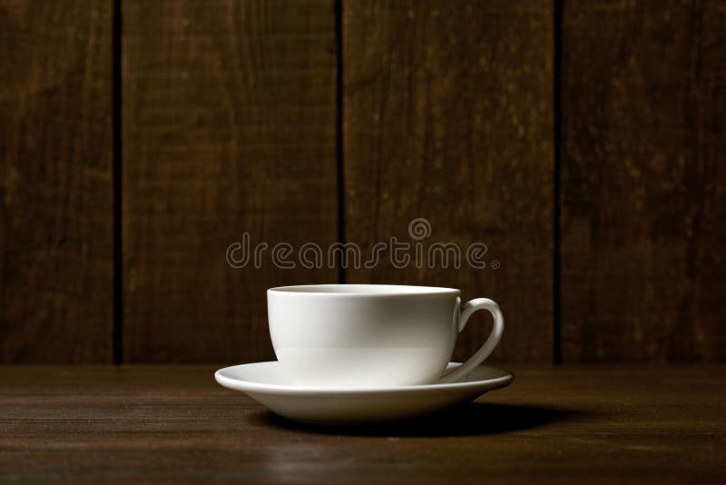 En klassisk kaffe- eller tekopp på en mörk träbakgrund royaltyfria bilder En klassisk kaffe- eller tekopp på en mörk träbakgrund royaltyfria bilder