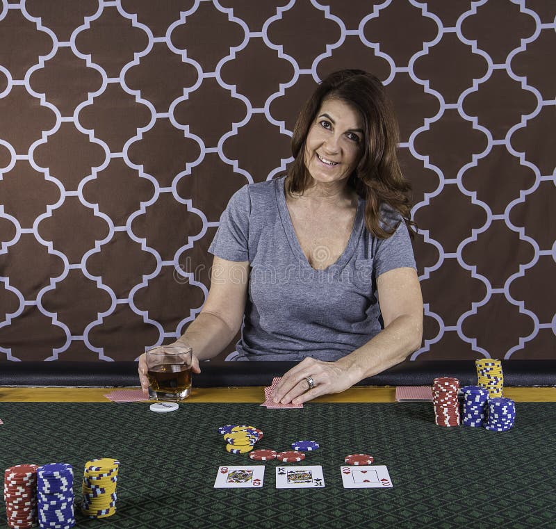 En kvinna som spelar poker på en tabell arkivbilder En kvinna som spelar poker på en tabell arkivbilder