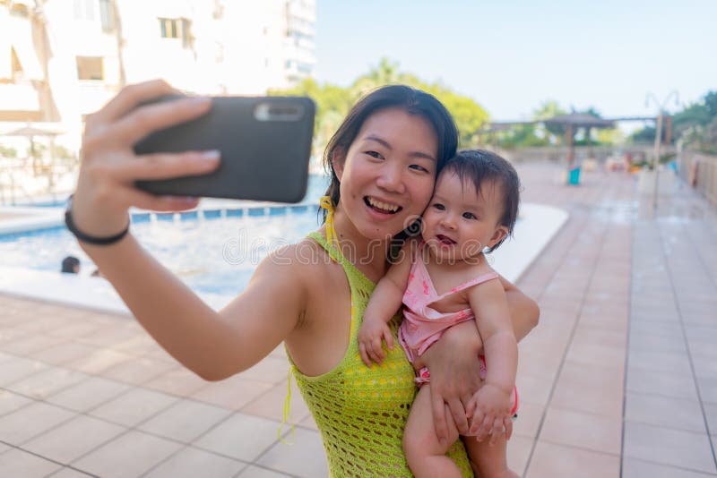 En kvinna som tar självfotografi med sin vackra flicka, vackra kinesiska mor som håller sin lilla dotter och tar med sig sin lilla arkivbilder