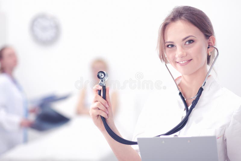 En kvinnlig doktor With en stetoskop som lyssnar arkivbilder En kvinnlig doktor With en stetoskop som lyssnar arkivbilder