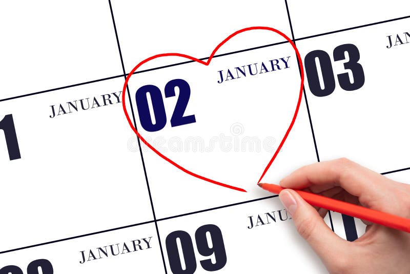 2nd day of January. A woman&#x27;s hand drawing a red heart shape on the calendar date of 2 January. Heart as a symbol of love. Winter month. Day of the year concept. 2nd day of January. A woman&#x27;s hand drawing a red heart shape on the calendar date of 2 January. Heart as a symbol of love. Winter month. Day of the year concept