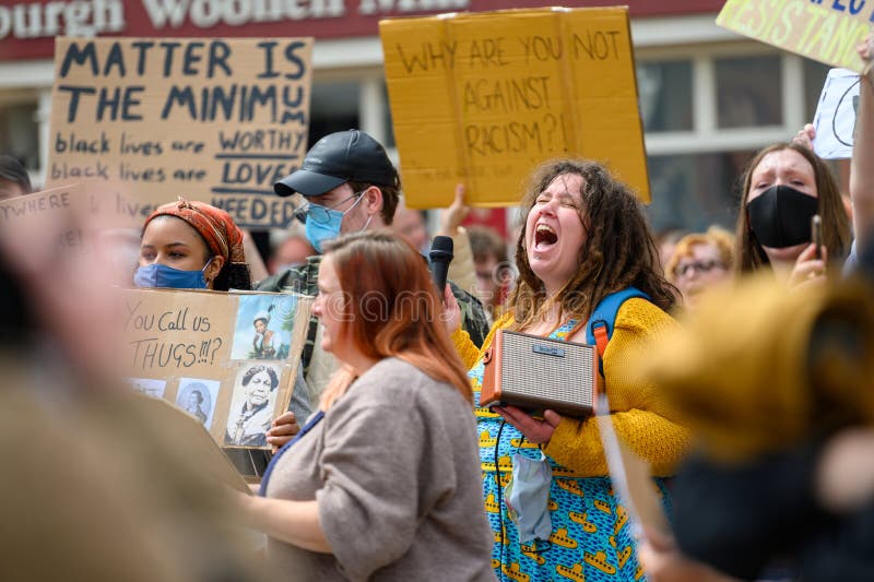 Richmond, North Yorkshire, UK - June 14, 2020: A Female protester screaming at a Black Lives Matter protest. Surrounded by other protesters who wear PPE Face Masks. Richmond, North Yorkshire, UK - June 14, 2020: A Female protester screaming at a Black Lives Matter protest. Surrounded by other protesters who wear PPE Face Masks