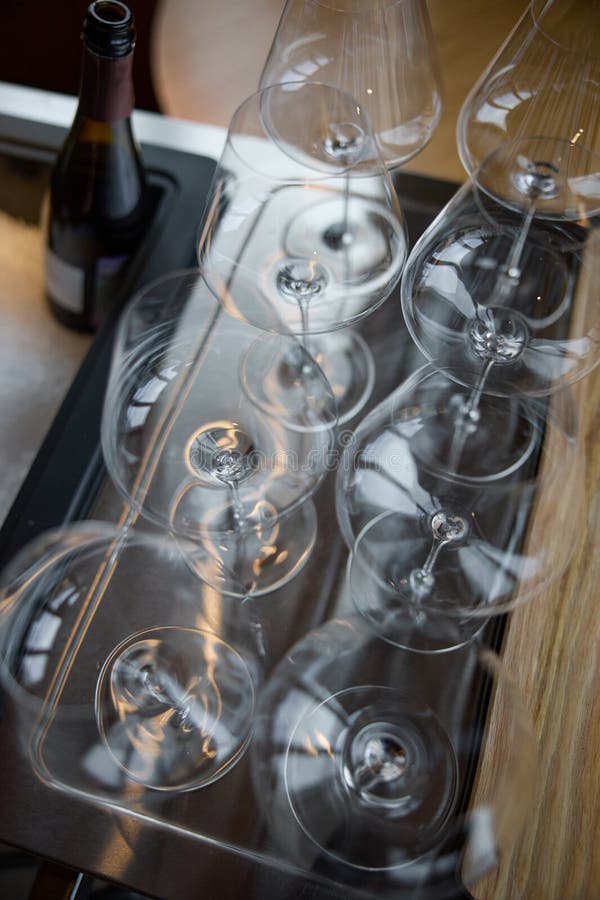 En la mesa de una bodega especial se ofrecen copas de vino limpias, una mesa elegante con una botella de vino espumoso fotos de archivo