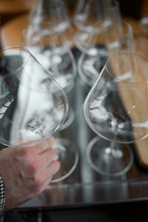 En la mesa de una bodega especial se ofrecen copas de vino limpias, una mesa elegante con una botella de vino espumoso fotos de archivo