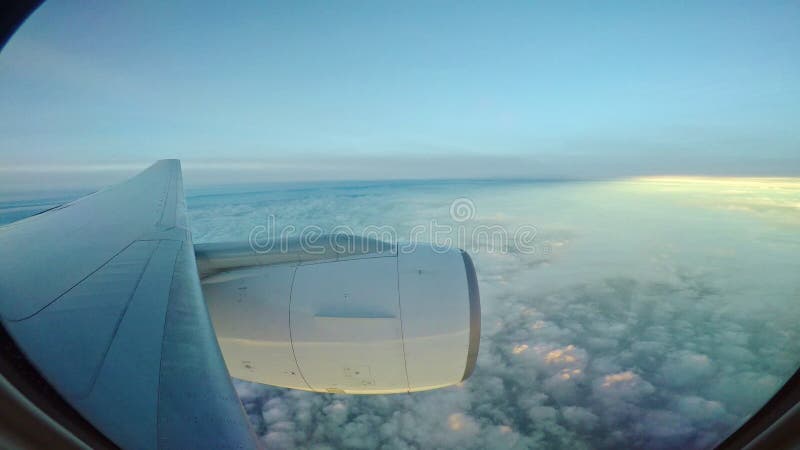 En la opinión plana de la ventana del vuelo del avión de reacción sobre scape de la nube