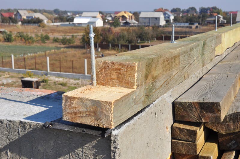 En la pared de ladrillo se ha instalado una viga de madera con impermeabilización para la construcción de los techos de madera imágenes de archivo libres de regalías