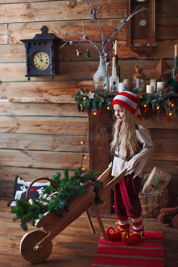 En liten liten flicka leprechaun gnome leker med pushcart arkivfoton