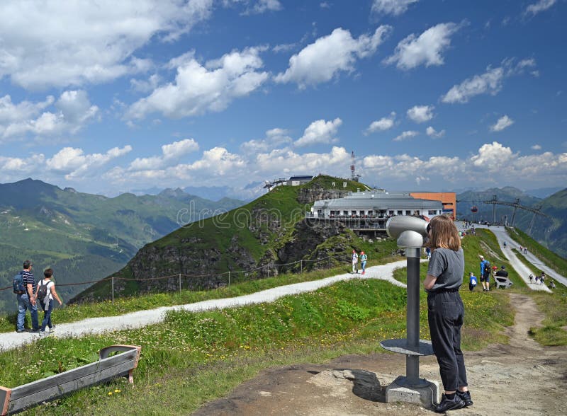 En liten flicka som tittar igenom synkarbinokulära på stubnerkogel bergsberg arkivbilder