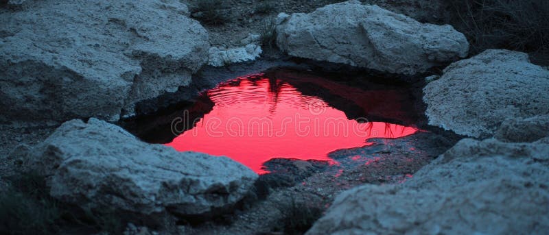 En liten vattenreservoar med en röd reflektion över himlen arkivfoton