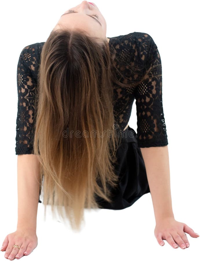 En LongHated Woman i ett svart lace Top Bending Overwards i ett isolerat fack arkivfoton