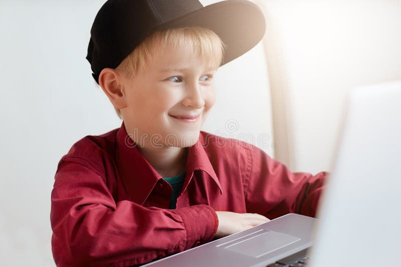En lycklig pys i moderiktig kläder som kopplar av under lunch på det moderna kafét som framme sitter av den öppna bärbara datorn royaltyfria bilder En lycklig pys i moderiktig kläder som kopplar av under lunch på det moderna kafét som framme sitter av den öppna bärbara datorn royaltyfria bilder