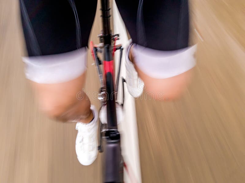 En lägre kroppsdel av en manlig cyklist i för ridningväg för cyklist som den enhetliga cykeln är rörande framåtriktat på gatan me arkivfoto En lägre kroppsdel av en manlig cyklist i för ridningväg för cyklist som den enhetliga cykeln är rörande framåtriktat på gatan me arkivfoto
