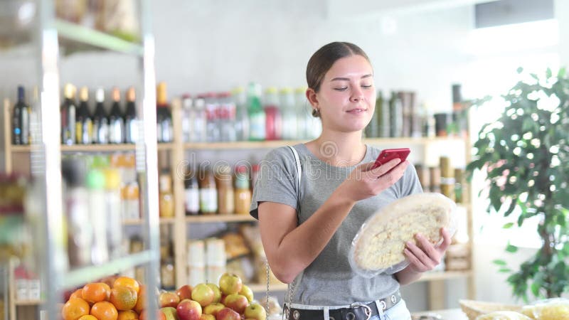 En magasin Jeune fille européenne scanner le code QR et prendre lecture de quatre pizza au fromage à l'aide de caméra téléphonique clips vidéos