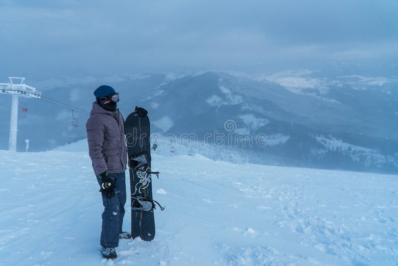 En man i bergen Snowboard i hand sport Snowboarder royaltyfri foto En man i bergen Snowboard i hand sport Snowboarder royaltyfri foto