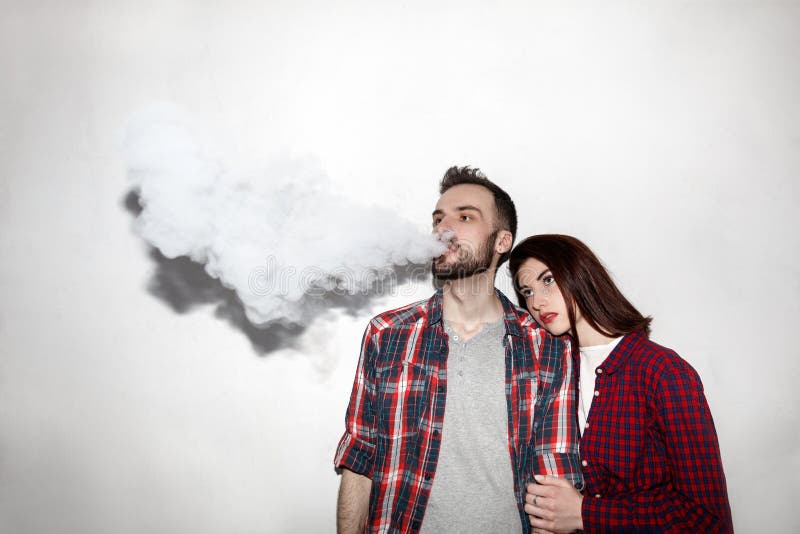 En man och en kvinna som röker elektronisk cigarettvape arkivfoto En man och en kvinna som röker elektronisk cigarettvape arkivfoto
