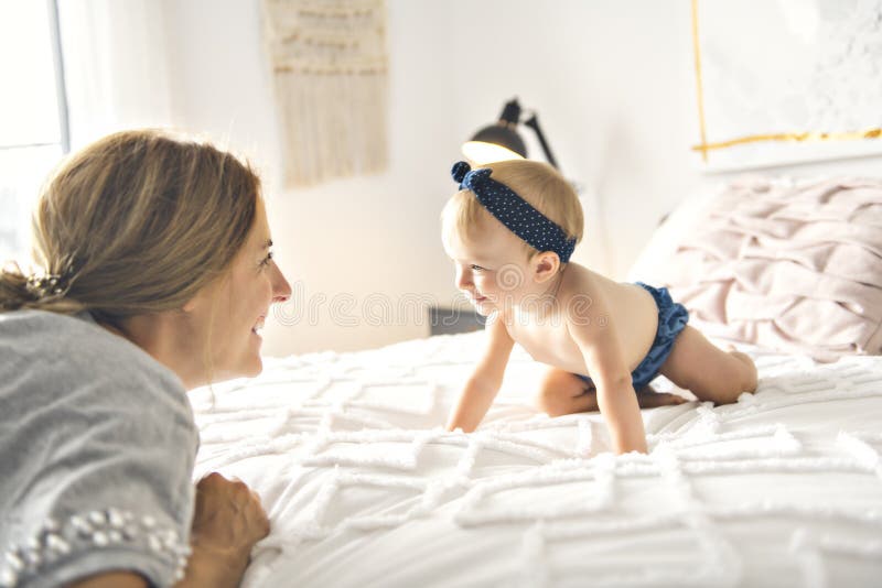 En moder och behandla som ett barn flickan på säng royaltyfria bilder En moder och behandla som ett barn flickan på säng royaltyfria bilder