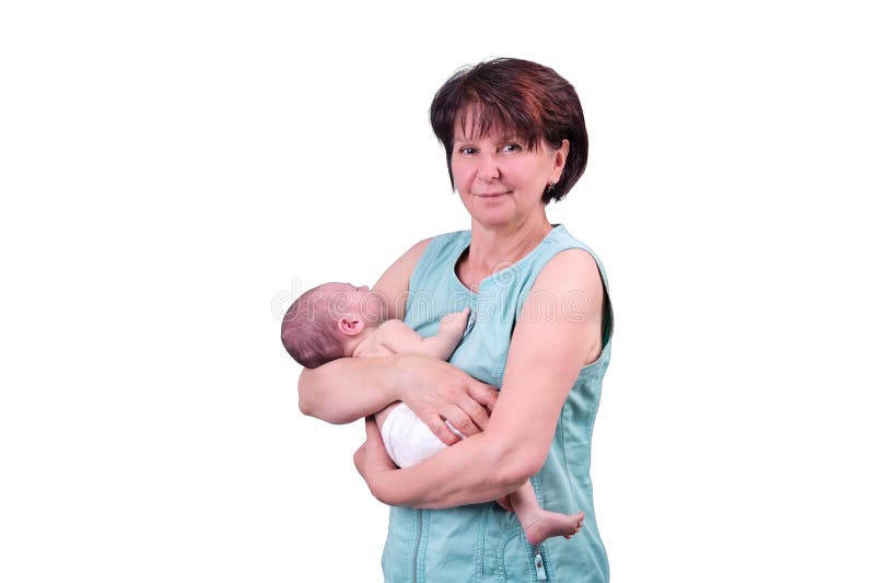 En mormor håller ett nyfött barn i armarna en studio som skjutits isolerad på vit bakgrund. Barn i åldern 0 månader arkivbild