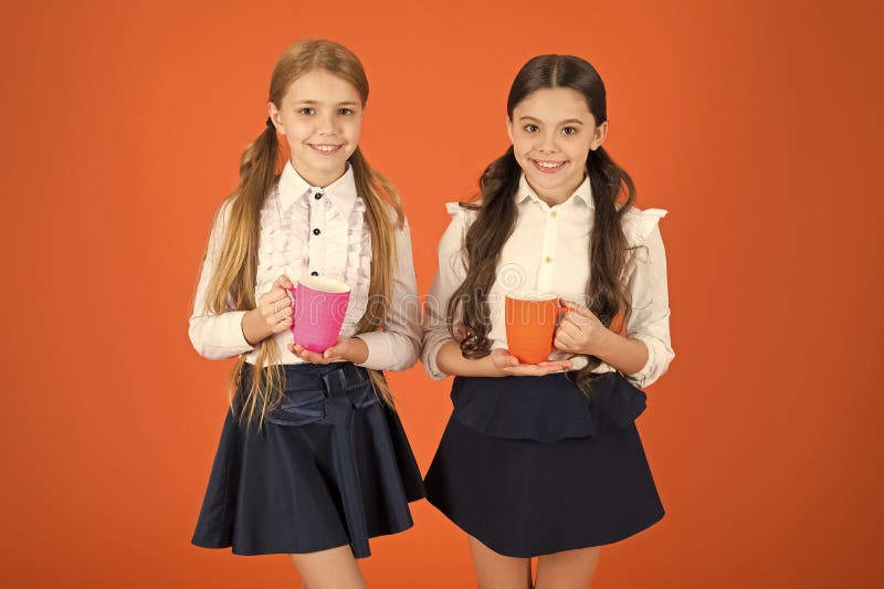 En mycket bra morgon till dig Sm? barn som dricker morgonte eller kaffe Gulliga skolflickor som rymmer tekoppar skola arkivfoton En mycket bra morgon till dig Sm? barn som dricker morgonte eller kaffe Gulliga skolflickor som rymmer tekoppar skola arkivfoton