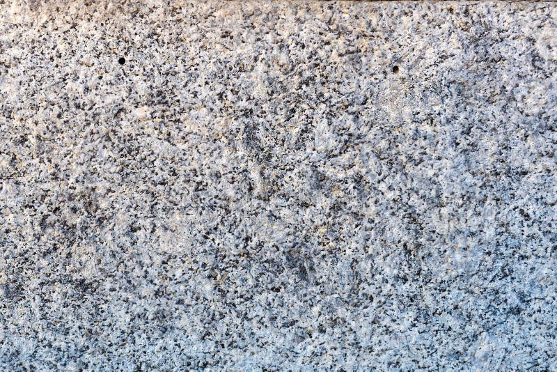 En närbild av en yttersida av behandlad grå granit vaggar plattan Ett fragment av en garnering för stenvägg royaltyfri fotografi