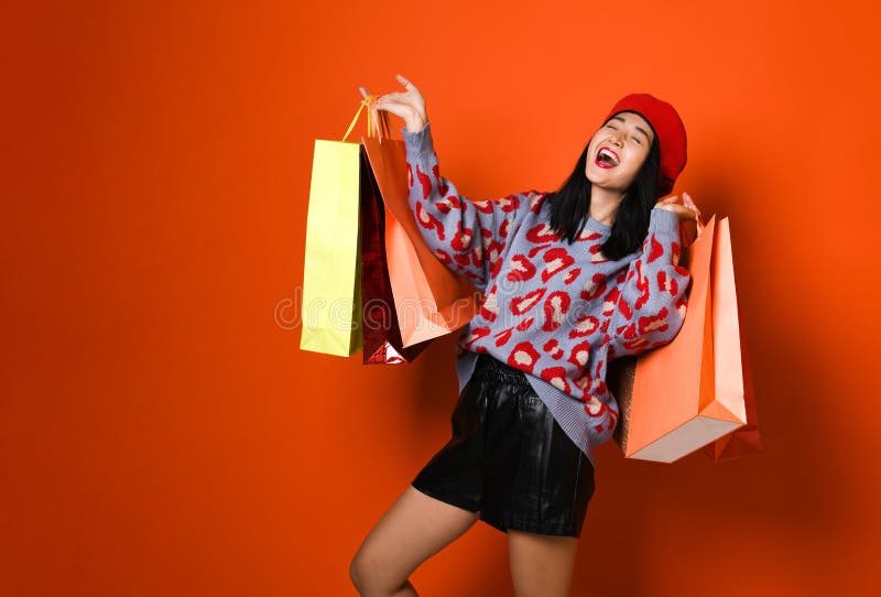 En nätt ung kvinna som stylishly är iklädd en hatt med påsar, når att ha shoppat fotografering för bildbyråer En nätt ung kvinna som stylishly är iklädd en hatt med påsar, når att ha shoppat fotografering för bildbyråer