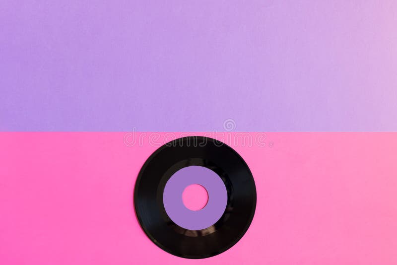 En omodern vinyldiskett på enton pappersbakgrund: rosa och violett, popkultur Top beskådar Minimalism bästa sikt med kopian arkivbilder En omodern vinyldiskett på enton pappersbakgrund: rosa och violett, popkultur Top beskådar Minimalism bästa sikt med kopian arkivbilder