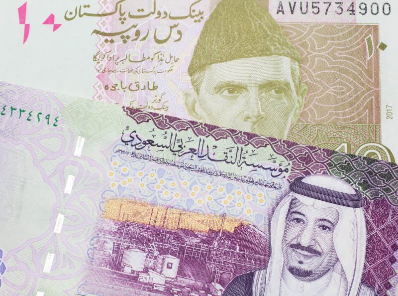 En pakistanskt rupt-sedel med fem saudisk banksedlar arkivfoto