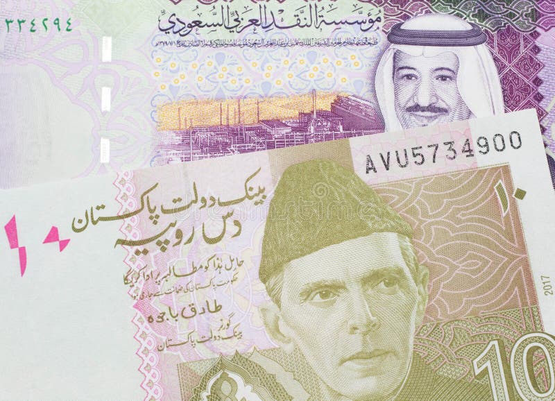 En pakistanskt rupt-sedel med fem saudisk banksedlar royaltyfri foto