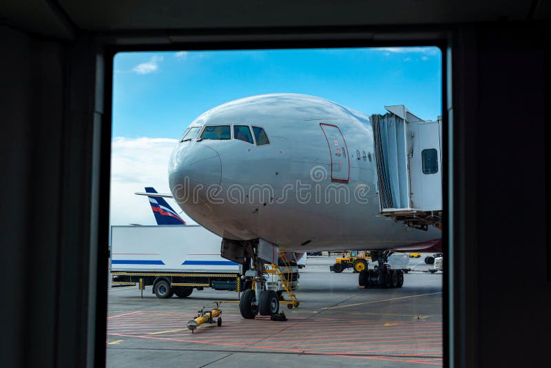 En passagerarenivå står på flygplatsen i en parkeringsplats som väntar på avvikelse, processen av att förbereda sig för flyget, ä royaltyfri foto En passagerarenivå står på flygplatsen i en parkeringsplats som väntar på avvikelse, processen av att förbereda sig för flyget, ä royaltyfri foto