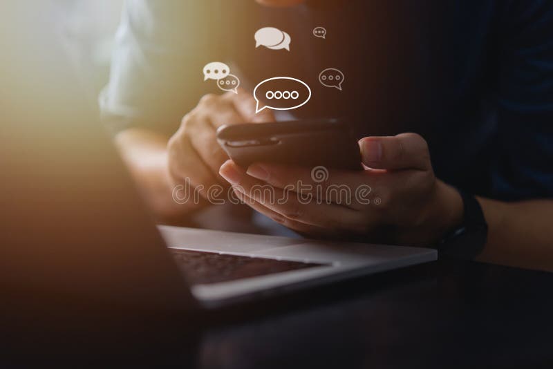 En person som använder en smarttelefon med chattikoner i flytande form symboliserar nätverk för mobil teknik online och effektiva arkivfoton