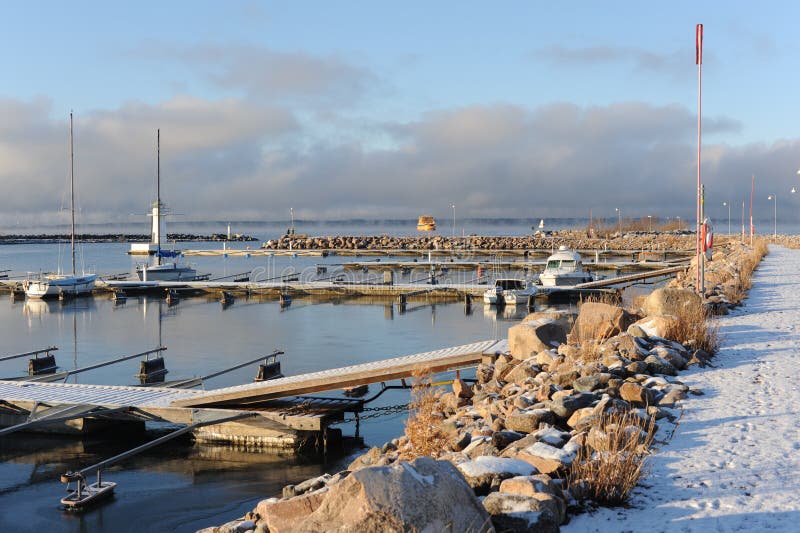 En pir på en hamn på vattersjön i granna i svden en solnyare vinterdag med vit blåsken klar luft och vatten
