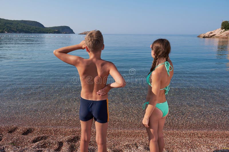 En pojke och en flicka tittar på avståndet på havsstranden. sommarsemester på semester royaltyfria foton
