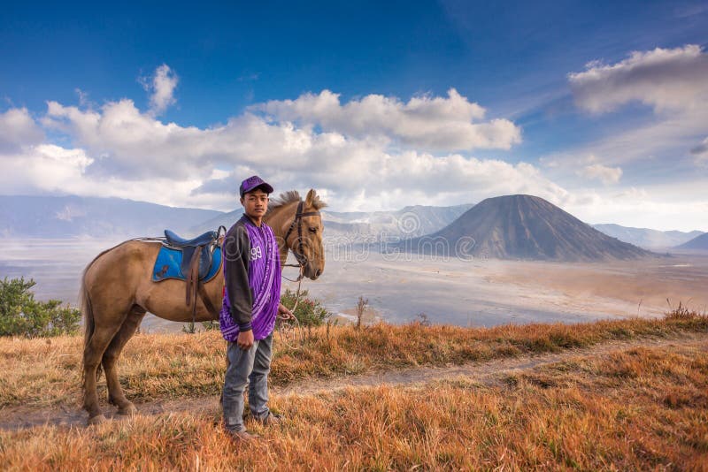 En pojke och hans häst på den Bromo Tengger Semeru nationalparken royaltyfria bilder En pojke och hans häst på den Bromo Tengger Semeru nationalparken royaltyfria bilder