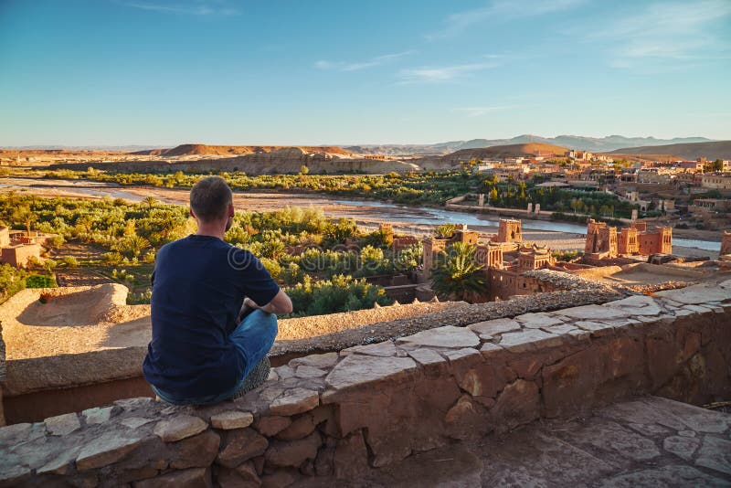 En pojke som mediterar på kanten av den forntida ksar Ait Ben Haddou royaltyfri foto En pojke som mediterar på kanten av den forntida ksar Ait Ben Haddou royaltyfri foto
