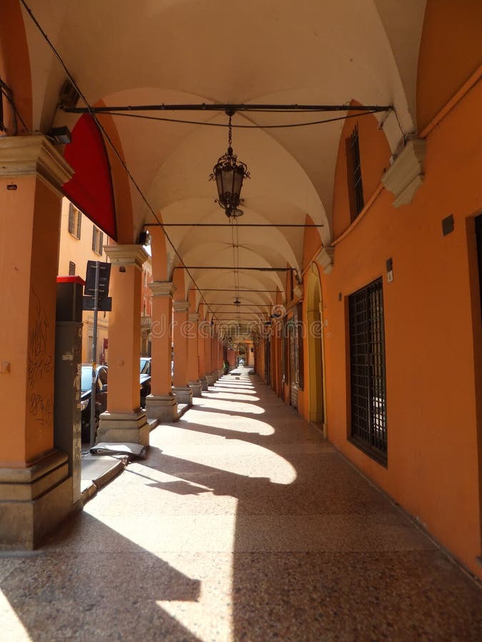 En portik i bolognaen, Italien Kolonner som skapar kors, skuggar på stentrottoaren fotografering för bildbyråer En portik i bolognaen, Italien Kolonner som skapar kors, skuggar på stentrottoaren fotografering för bildbyråer